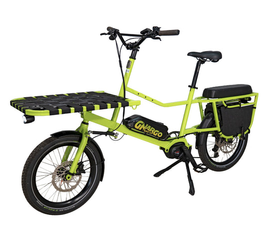 A bright neon yellow-green cargo bike with a black seat, black tires, a black rear cargo bag, and a black front cargo platform with yellow hazard stripes. The frame features the brand name 'GNARGO' in yellow.